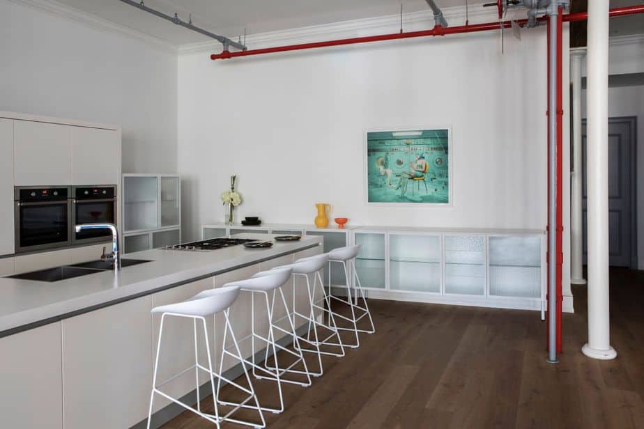 Khu bếp màu trắng sang trọng và cực kỳ rộng rãi của thiết kế căn hộ phong cách Soho