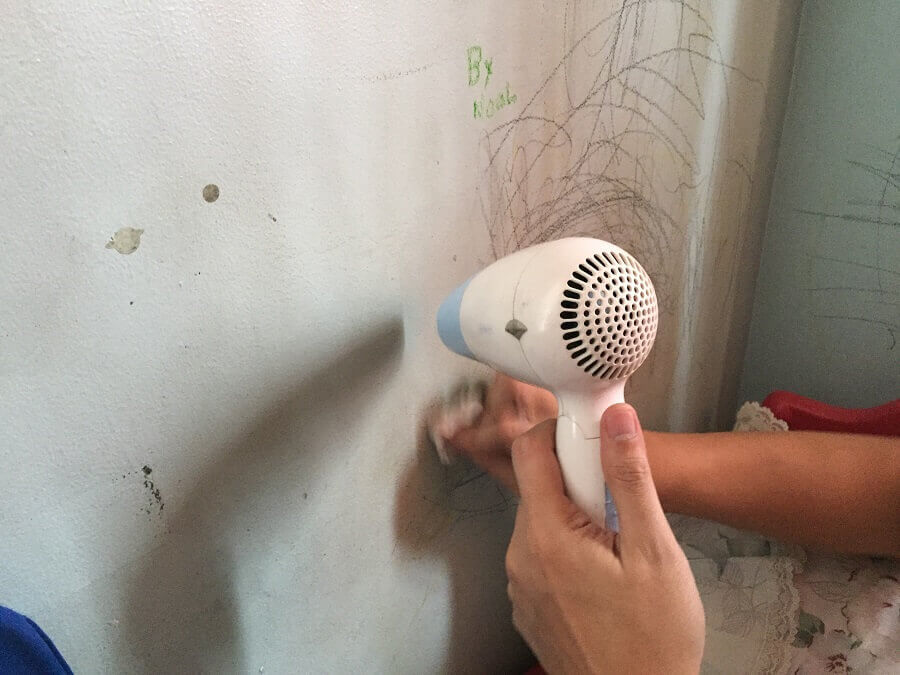 vết bẩn trên tường: Giấy ướt lau bề mặt tường có dính sáp màu và dùng máy sấy khô tường